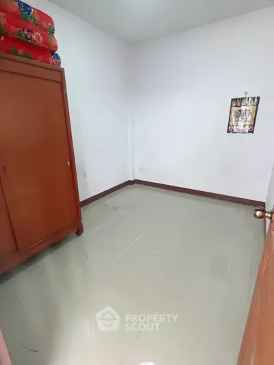 Spacious empty room with wardrobe and tiled floor, perfect for customization.