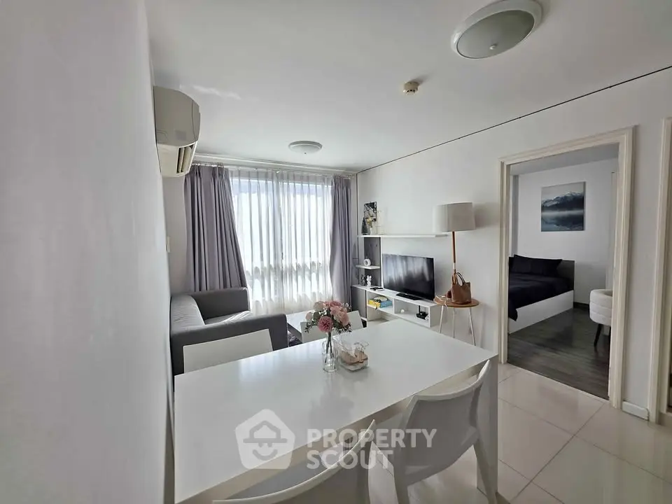 Modern living room with dining area and bedroom view in a stylish apartment