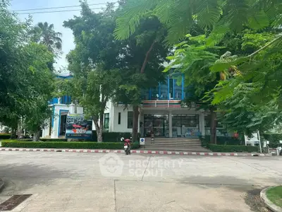 Modern building exterior with lush greenery and spacious entrance
