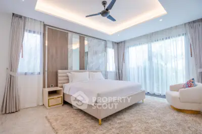 Luxurious bedroom with elegant decor and large windows offering natural light