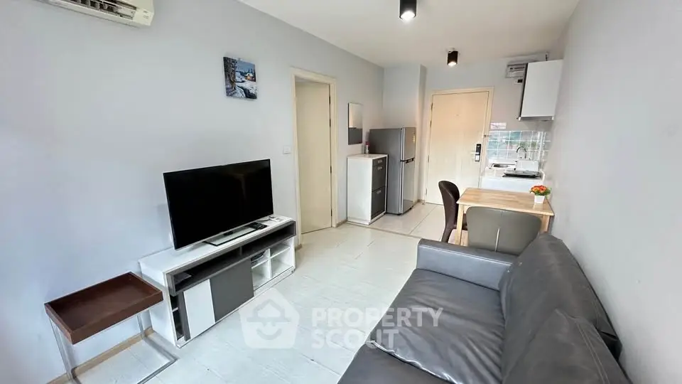 Modern living room with sleek furniture and open kitchen layout.