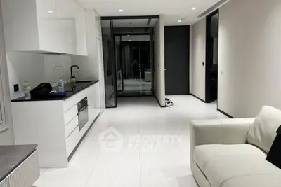 Modern minimalist living room with sleek white cabinetry and comfortable sofa.