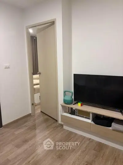 Modern living room with wooden flooring and sleek TV setup