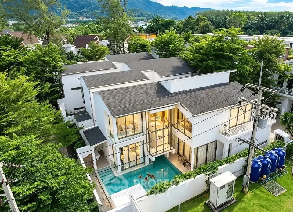 Luxurious modern villa with private pool and stunning mountain views, surrounded by lush greenery.