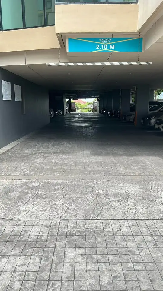 Covered parking entrance with height restriction sign in modern building