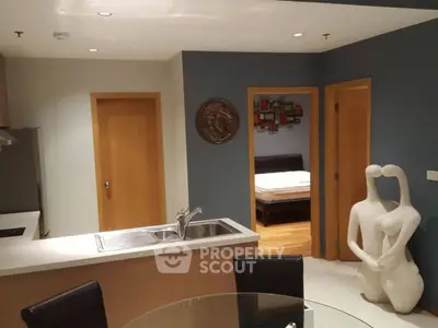 Modern apartment interior with open kitchen and unique sculpture decor