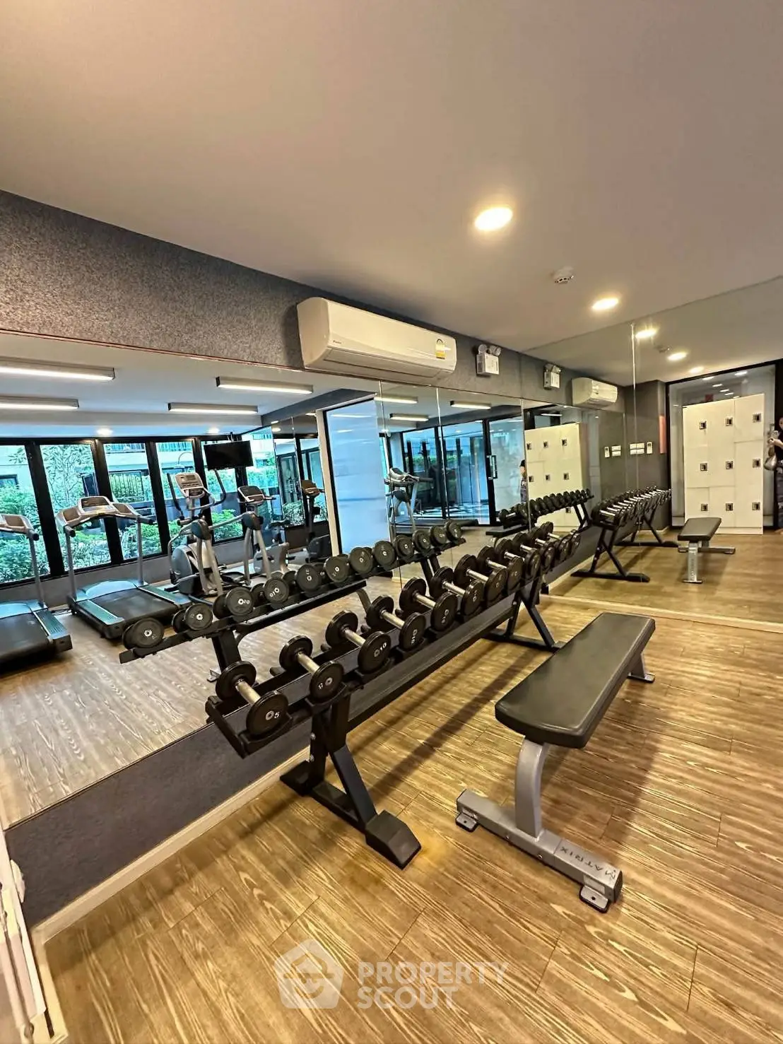 Modern gym with state-of-the-art equipment and mirrored walls in a luxury residential building.