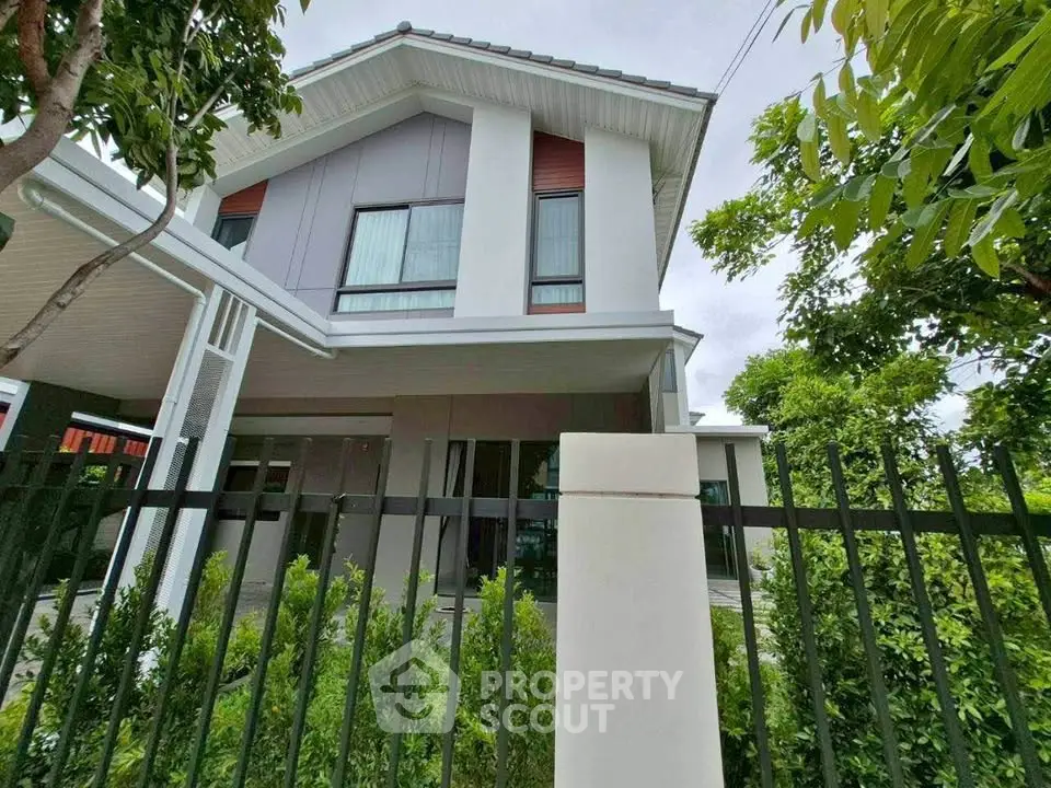 Modern two-story house with sleek design and lush greenery, perfect for family living.