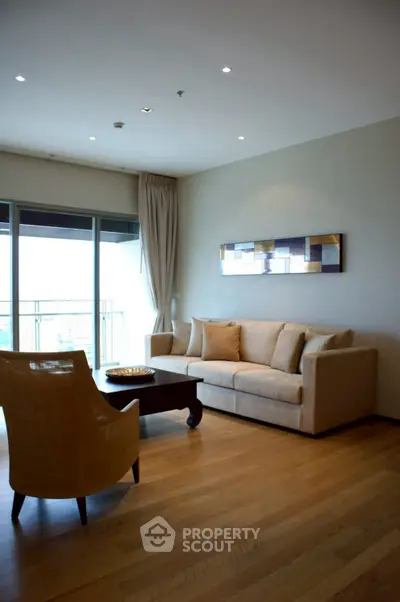 Elegant living room with modern furniture and large balcony view.
