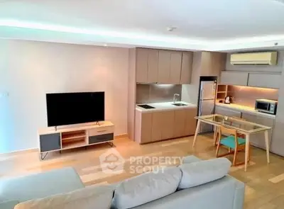 Modern open-plan living room with sleek kitchen and cozy seating area.