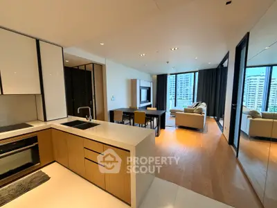 Modern open-plan living room with kitchen, featuring sleek design and city view.