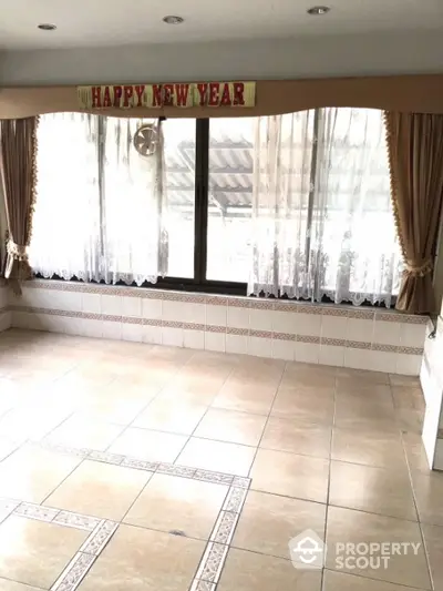 Spacious tiled room with large windows and festive Happy New Year banner.