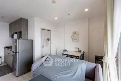 Modern apartment with open kitchen and cozy dining area, featuring sleek appliances and stylish decor.