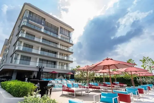 Luxurious modern apartment building with stylish outdoor pool area and sun loungers.