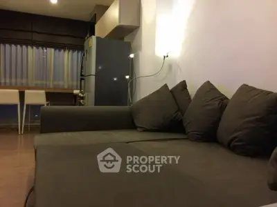 Modern living room with cozy sofa and dining area in open layout apartment.