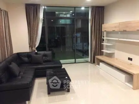 Modern living room with sleek black sofa and stylish shelving unit