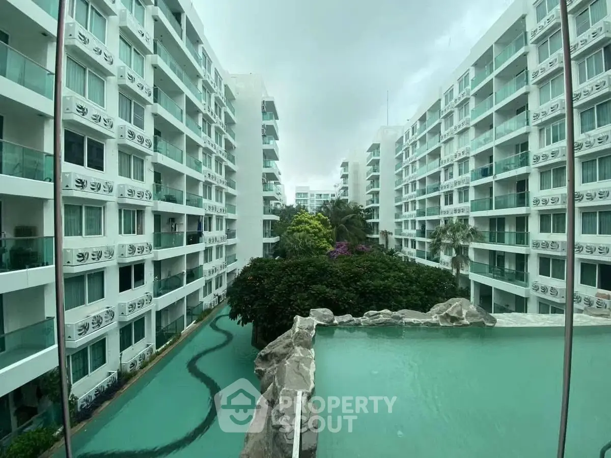 Stunning view of modern apartment complex with pool and lush greenery