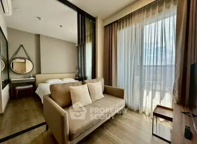 Modern studio apartment with cozy living area and bedroom, featuring large windows and stylish decor.