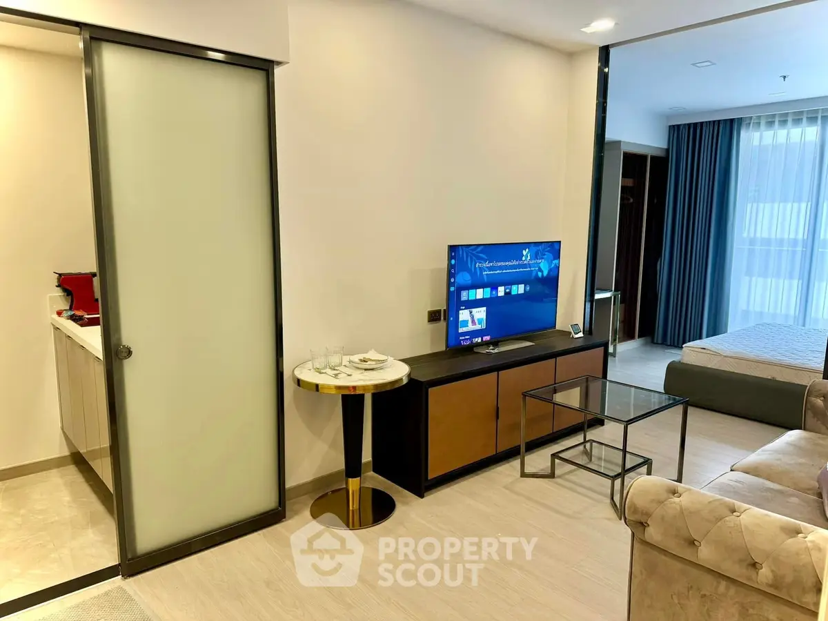 Modern living room with elegant furniture and open layout, featuring a cozy bedroom view.