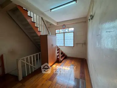 Spacious interior with wooden flooring and staircase, perfect for creative renovation.