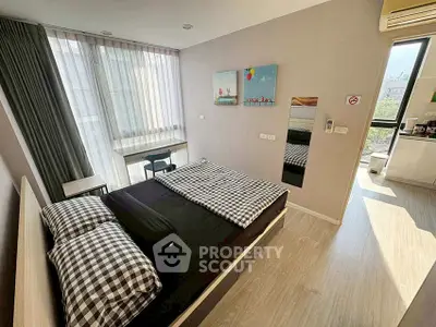 Modern bedroom with stylish decor and natural light, featuring a comfortable bed and a small desk by the window.