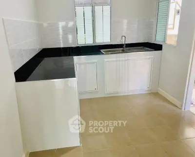 Modern kitchen with sleek black countertops and white cabinetry