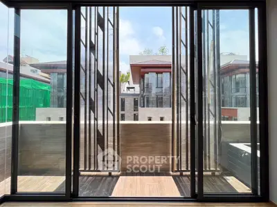 Modern balcony with sleek glass doors and urban view, perfect for city living.