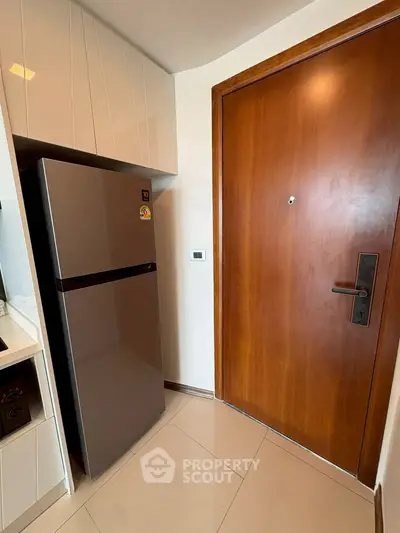 Modern kitchen corner with sleek fridge and wooden door