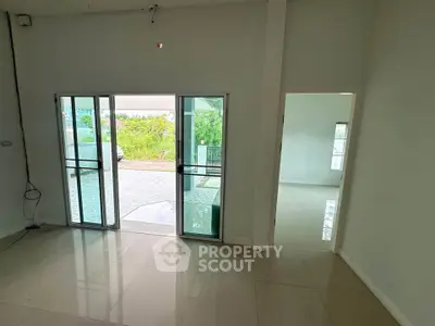Spacious interior with sliding glass doors leading to a serene outdoor view, perfect for modern living.