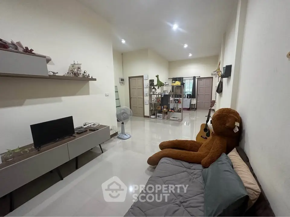 Spacious living room with modern decor and plush teddy bear, perfect for relaxation and entertainment.