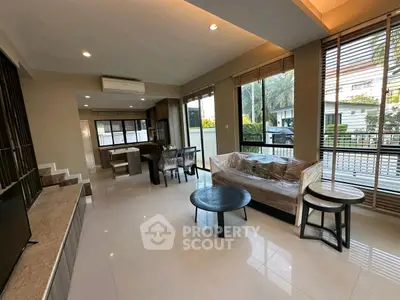 Spacious modern living room with large windows and stylish furniture in a contemporary home.