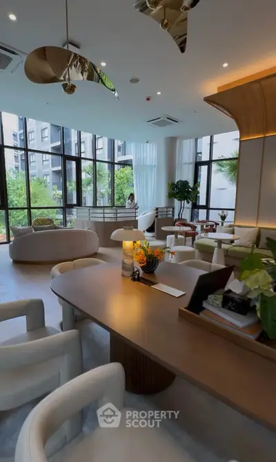 Luxurious modern living room with elegant furniture and large windows offering garden views.