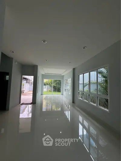 Spacious modern living room with large windows and glossy floors