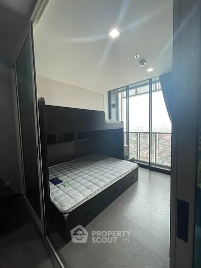 Modern bedroom with bunk bed and city view through large windows