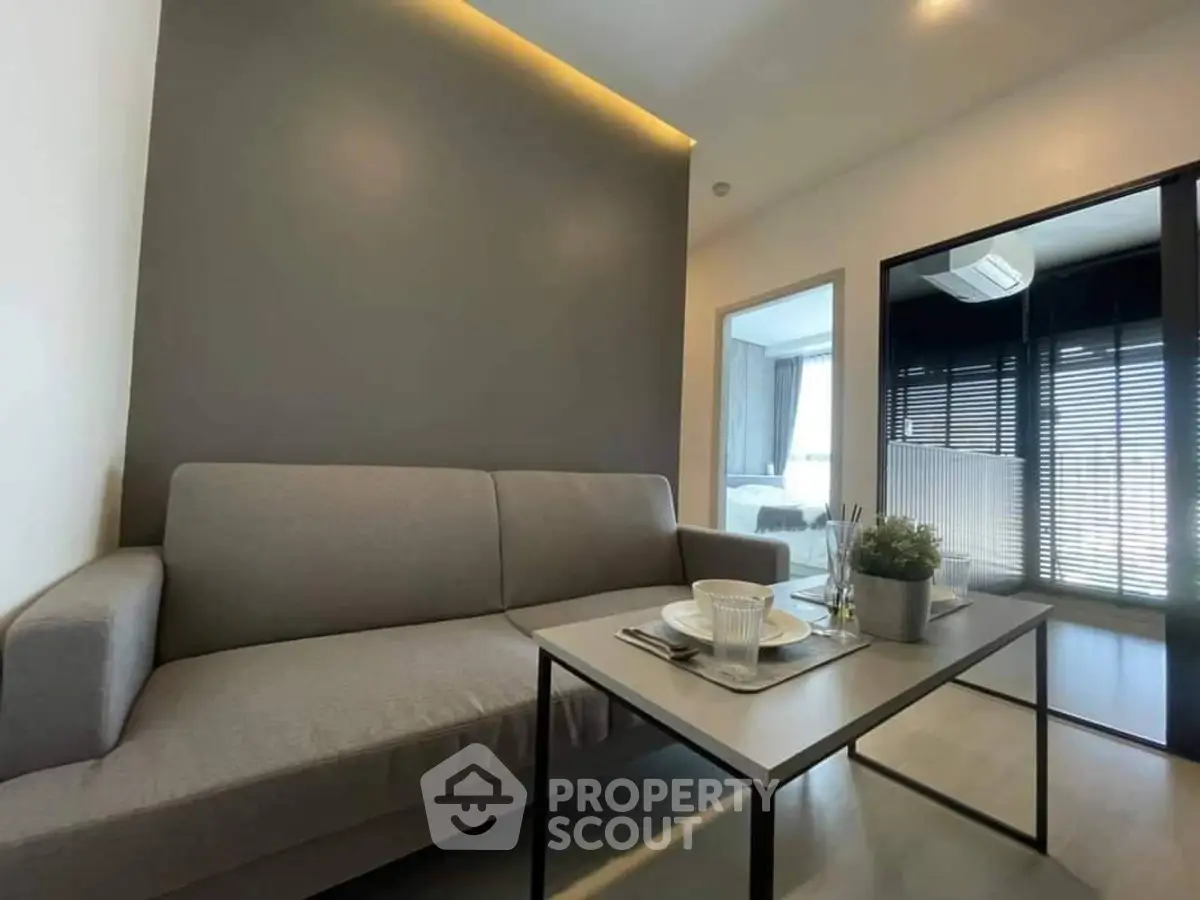 Modern living room with sleek gray sofa and stylish decor in a contemporary apartment.