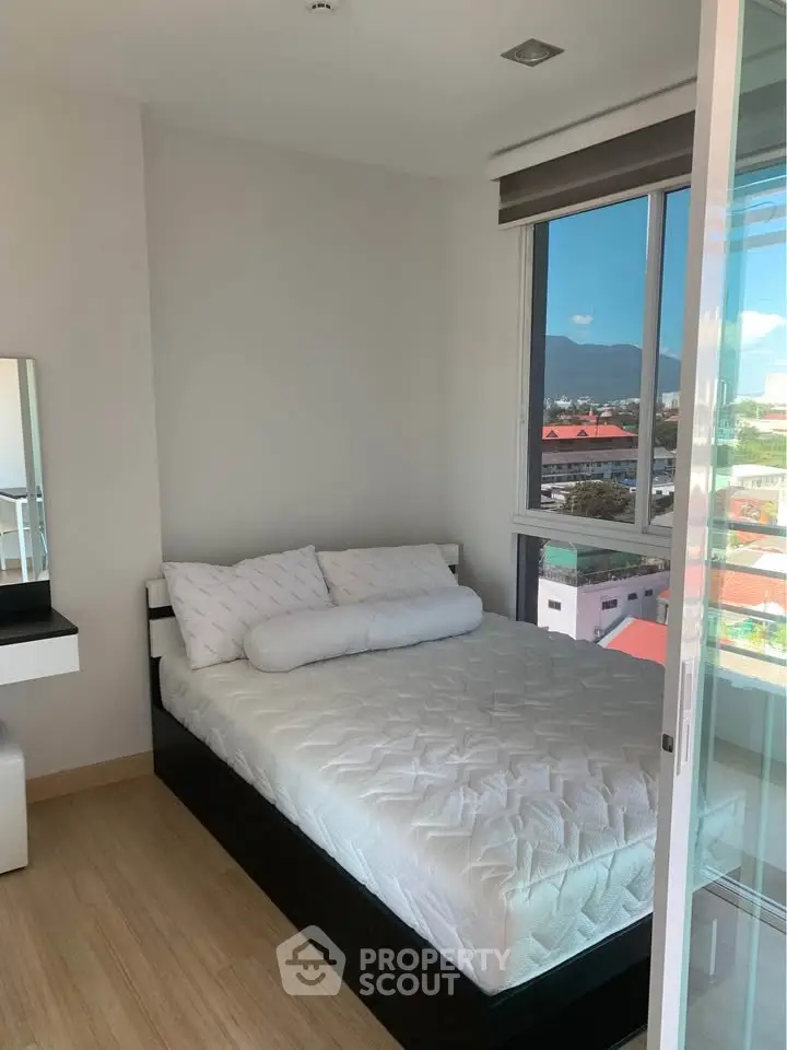Cozy bedroom with mountain view and modern decor in a bright apartment.