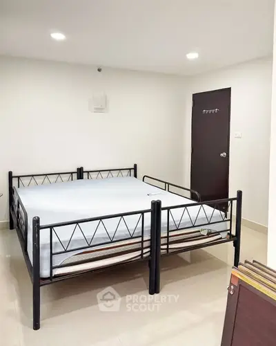 Spacious bedroom with modern metal bed frame and minimalist decor