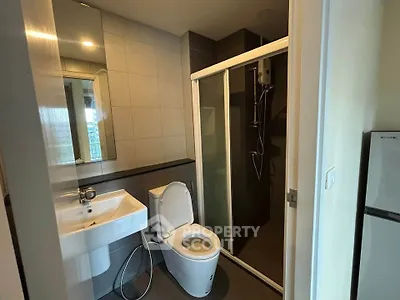 Modern bathroom with sleek fixtures and glass shower enclosure in a contemporary apartment.