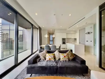 Luxurious modern living room with floor-to-ceiling windows and open kitchen layout in high-rise apartment.