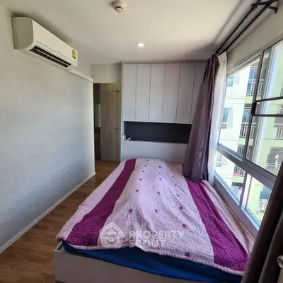 Cozy bedroom with large window and air conditioning in modern apartment