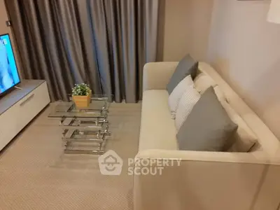 Modern living room with stylish sofa and glass coffee table, perfect for cozy relaxation.