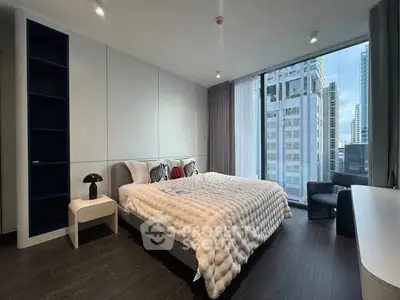 Luxurious bedroom with city view, modern furnishings, and floor-to-ceiling windows in high-rise apartment.