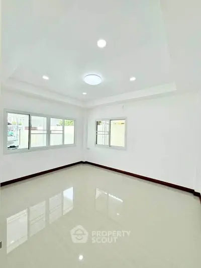 Bright and spacious empty room with large windows and glossy tiled floor, perfect for customization.