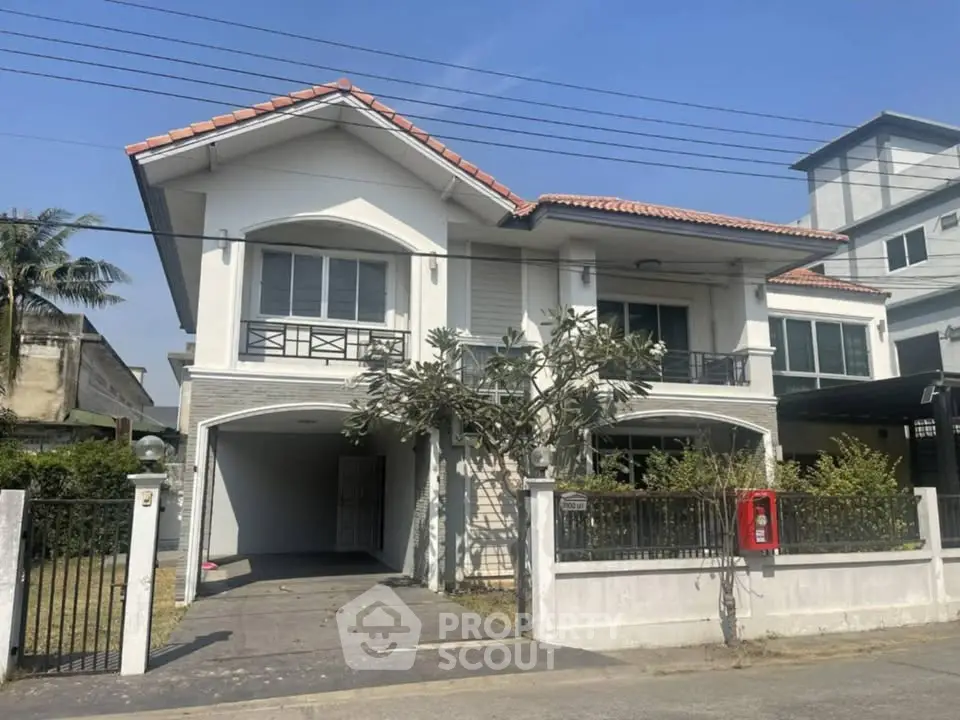 Charming two-story house with tiled roof and spacious driveway in a serene neighborhood.
