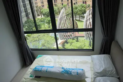 Cozy bedroom with large window offering stunning garden view in modern apartment
