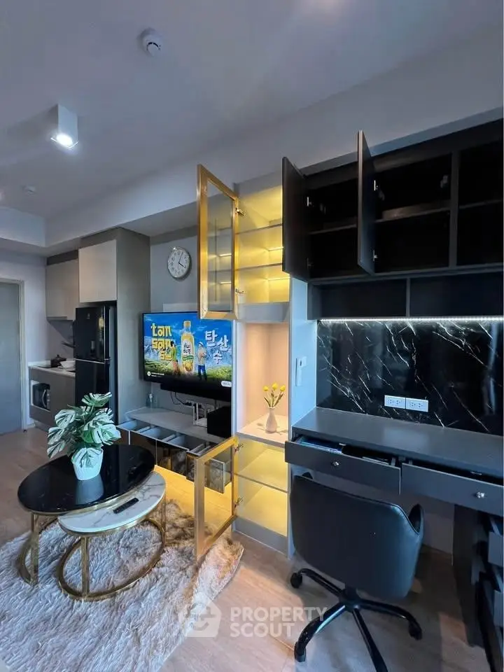 Modern living room with sleek furniture and open kitchen layout, featuring stylish decor and ample storage.