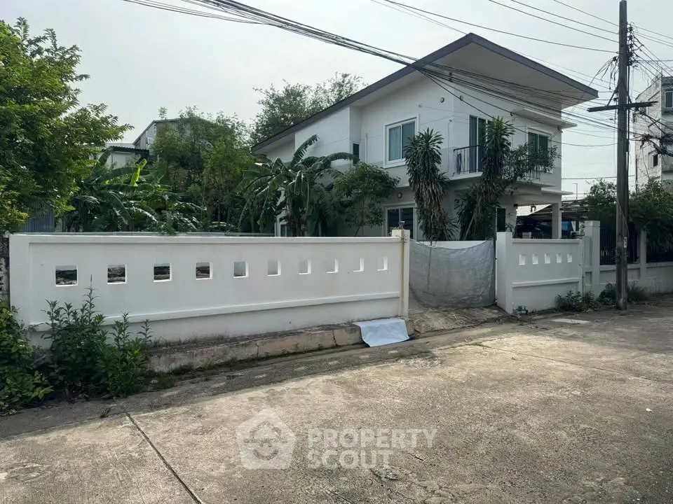 Charming two-story house with lush greenery and modern design in a serene neighborhood.