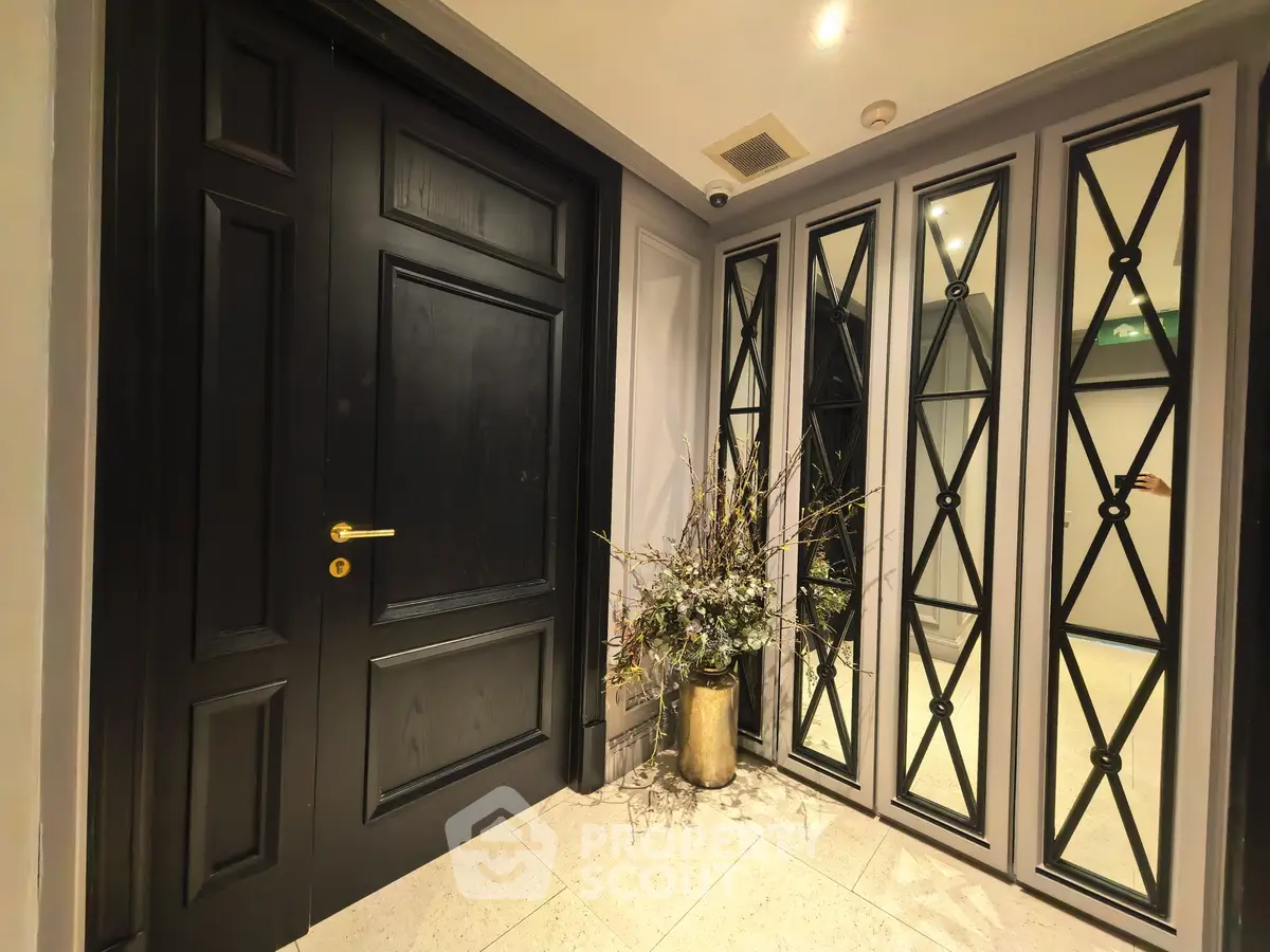 Elegant entrance with black door and mirrored panels in luxury building