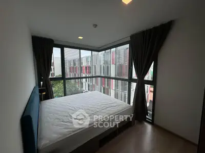 Modern bedroom with large windows offering a stunning view of the cityscape.