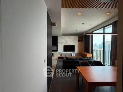 Modern living room with city view, featuring sleek furniture and large windows for natural light.